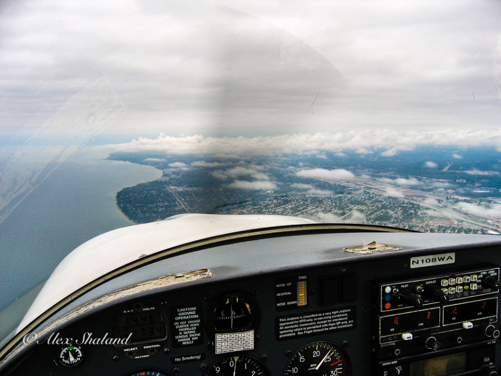 View from the cockpit of the airplane on the shoreline of Lake Erie.